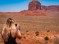 Young blonde girl takes a picture the Monument Valley Artist`s Point Royalty Free Stock Photo