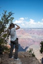 young blonde girl taking photos of the landscape of the Grand Canyon