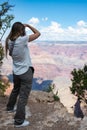 young blonde girl taking photos of the landscape of the Grand Canyon