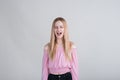 Young blonde girl upset and shouts in the studio on a white background. Royalty Free Stock Photo