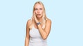 Young blonde girl wearing casual style with sleeveless shirt hand on mouth telling secret rumor, whispering malicious talk Royalty Free Stock Photo