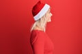 Young blonde girl wearing christmas hat looking to side, relax profile pose with natural face with confident smile Royalty Free Stock Photo