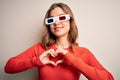 Young blonde girl wearing 3d cinema glasses over isolated background smiling in love showing heart symbol and shape with hands Royalty Free Stock Photo