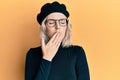 Young blonde girl wearing french look with beret bored yawning tired covering mouth with hand Royalty Free Stock Photo