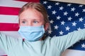 Young blonde girl wearing protection mask with American USA flag. Coronavirus, covid-2019 pray for USA.God bless America