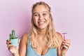 Young blonde girl wearing sportswear holding cactus and razor smiling and laughing hard out loud because funny crazy joke Royalty Free Stock Photo