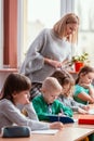 Blonde haired teacher with children in the classroom