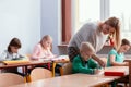 Blonde haired teacher with children in the classroom