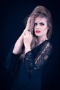 Young Blonde With Lace Black Dress Playing With Her Hair, on Deep Blue Background Royalty Free Stock Photo