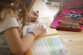 young blonde left-handed girl is training her handwriting while being home schooled