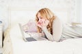 Young blonde lying on her bed using laptop Royalty Free Stock Photo