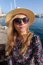 Young blonde Mediterranean traveler woman in hat portrait