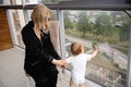 Young blonde mother having quality time with her baby boy son at family home flat - Wearing black budoir dress costume