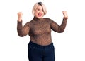 Young blonde plus size woman wearing casual leopard t-shirt screaming proud, celebrating victory and success very excited with Royalty Free Stock Photo