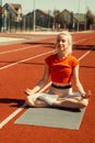 Young blonde relaxes on a sports mat