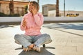 Young blonde skater girl talking on the smartphone and drinking coffee at the park Royalty Free Stock Photo