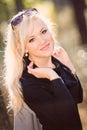 A young, blonde and smiling woman portrait on a sunny autumn day Royalty Free Stock Photo