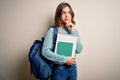 Young blonde student girl wearing backpack and books from school over isolated background serious face thinking about question, Royalty Free Stock Photo