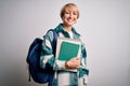 Young blonde student woman with short hair wearing backpack and holding university books with a happy face standing and smiling Royalty Free Stock Photo