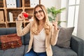 Young blonde therapist woman working on couple therapy at consultation office smiling happy pointing with hand and finger to the Royalty Free Stock Photo