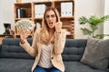 Young blonde therapist woman working at therapy office holding money annoyed and frustrated shouting with anger, yelling crazy Royalty Free Stock Photo