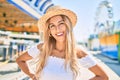 Young blonde tourist girl smiling happy looking to the camera at fairground