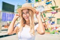 Young blonde tourist girl smiling happy looking to the camera at fairground