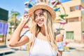 Young blonde tourist girl smiling happy looking to the side at fairground