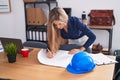 Young blonde woman architect drawing house plans at office Royalty Free Stock Photo