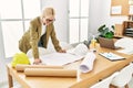 Young blonde woman architect looking house plans smiling at office Royalty Free Stock Photo