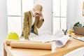 Young blonde woman architect looking house plans stressed at office Royalty Free Stock Photo