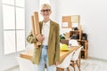 Young blonde woman architect smiling confident holding blueprints at office Royalty Free Stock Photo