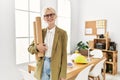 Young blonde woman architect smiling confident holding blueprints at office Royalty Free Stock Photo