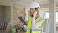 Young blonde woman architect talking on smartphone looking touchpad at construction site Royalty Free Stock Photo