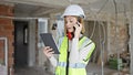 Young blonde woman architect talking on smartphone looking touchpad at construction site Royalty Free Stock Photo