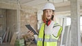 Young blonde woman architect talking on smartphone looking touchpad at construction site Royalty Free Stock Photo