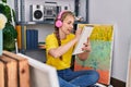 Young blonde woman artist listening to music drawing on notebook at art studio Royalty Free Stock Photo