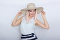 Young blonde woman with big white summer hat