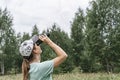 Young blonde woman bird watcher in cap and blue t-shirt looking through binoculars at cloudy sky in summer forest ornithological Royalty Free Stock Photo