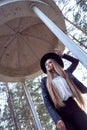 A Young Blonde Woman In A Black Hat Inside An Architectural Structure. A Black Leather Jacket And A White Shirt