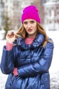 Young blonde woman in blue down jacket in winter street
