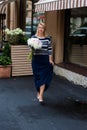 Young blonde woman in blue dress with peonies bouquet Royalty Free Stock Photo