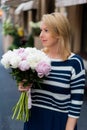 Young blonde woman in blue dress with peonies bouquet Royalty Free Stock Photo