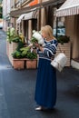 Young blonde woman in blue dress with peonies bouquet Royalty Free Stock Photo