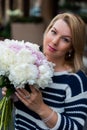 Young blonde woman in blue dress with peonies bouquet Royalty Free Stock Photo