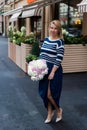 Young blonde woman in blue dress with peonies bouquet Royalty Free Stock Photo