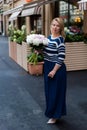 Young blonde woman in blue dress with peonies bouquet Royalty Free Stock Photo