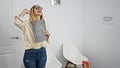 Young blonde woman business worker holding clipboard smiling confident celebrating at the office waiting room Royalty Free Stock Photo