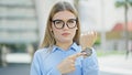 Young blonde woman business worker standing with serious expression pointing watch at street Royalty Free Stock Photo