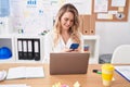 Young blonde woman business worker using laptop and smartphone at office Royalty Free Stock Photo